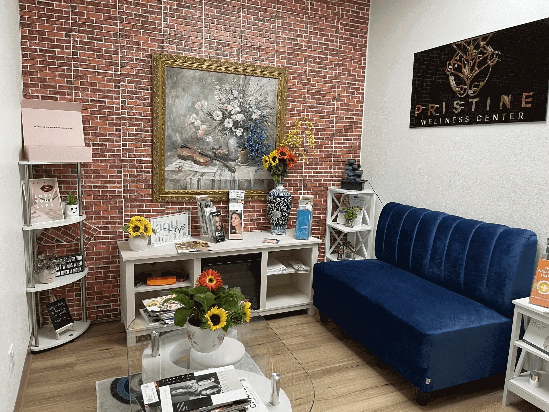 A living room with blue couch and brick wall