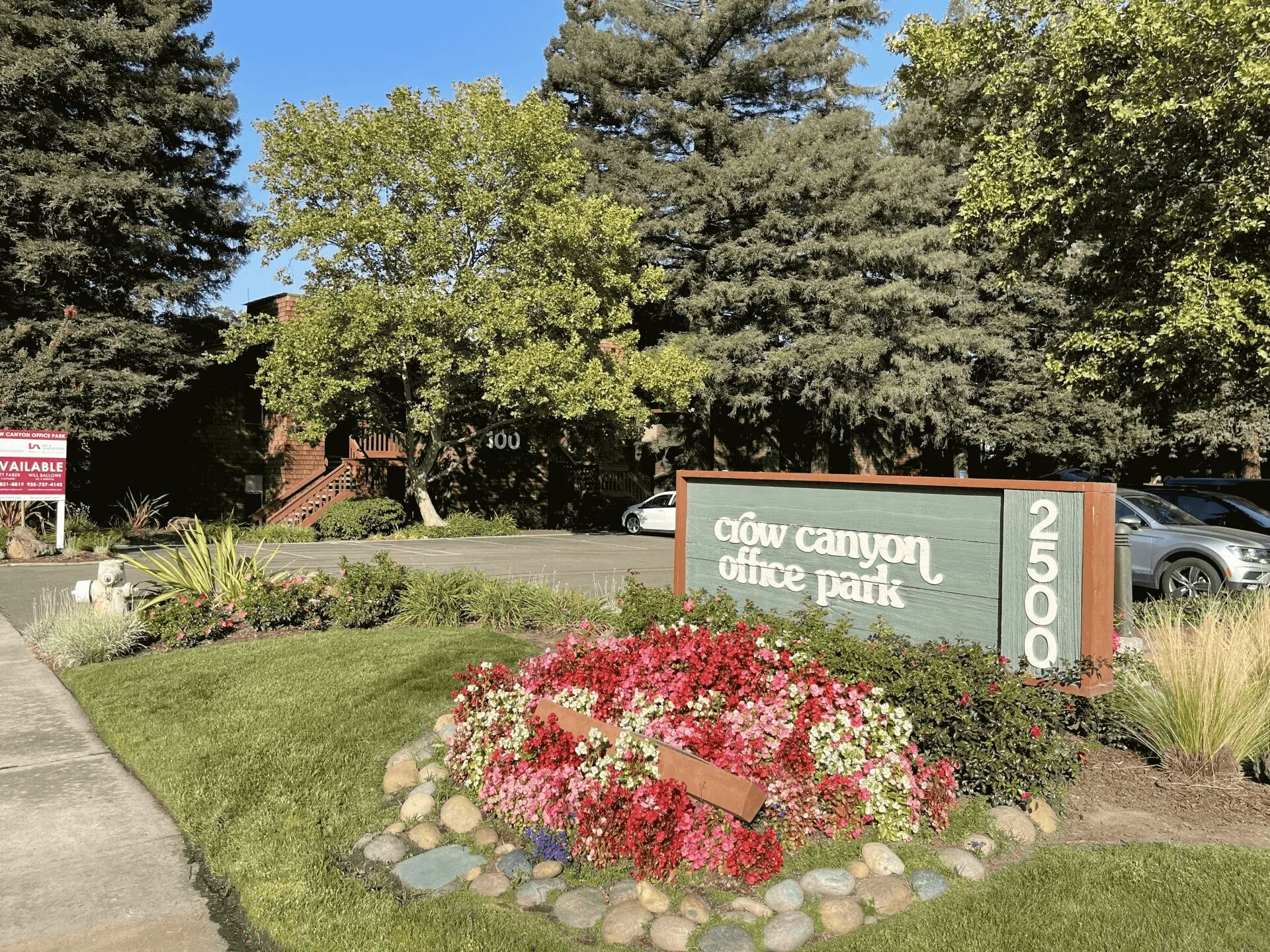 A sign that is in front of some flowers.