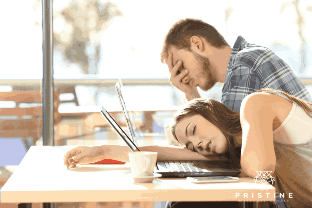 A man and woman are sleeping on the table