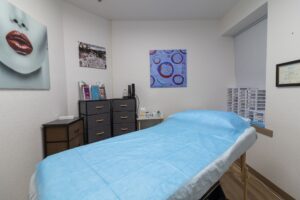 A bed room with a blue sheet and some drawers