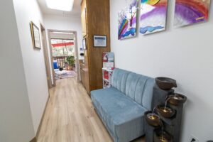 A blue couch in the middle of a hallway.