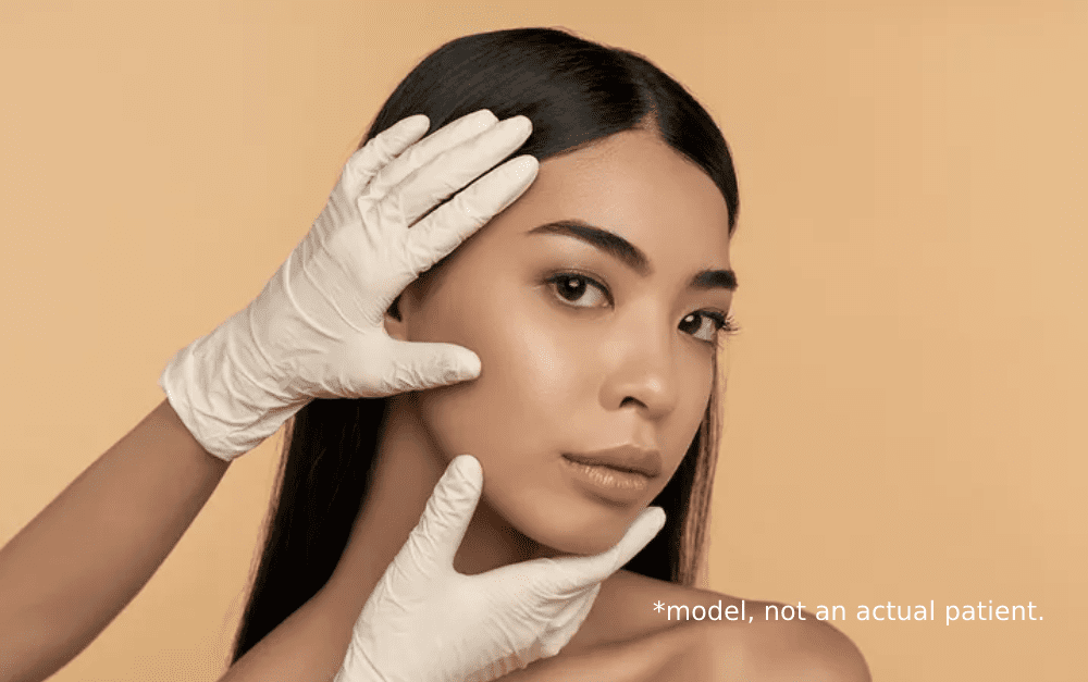 A woman with gloves on touching her face.