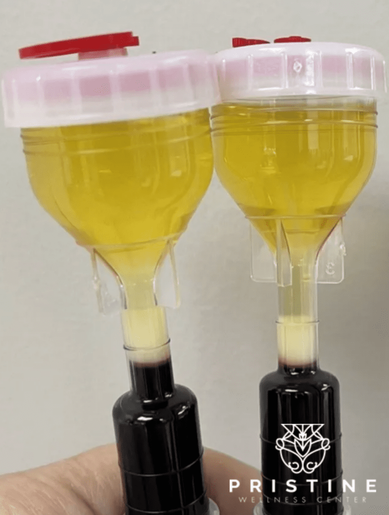 Two wine bottles with a pink lid on top of them.