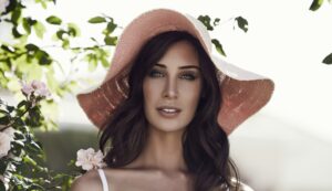 Woman in sun hat with flowers.