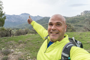Happy hiker thumbs up mountain view.